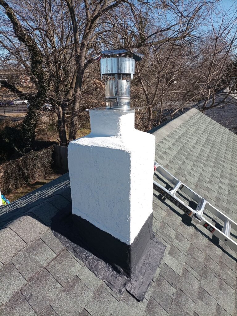 Finished chimney with smooth white stucco coating and new cap