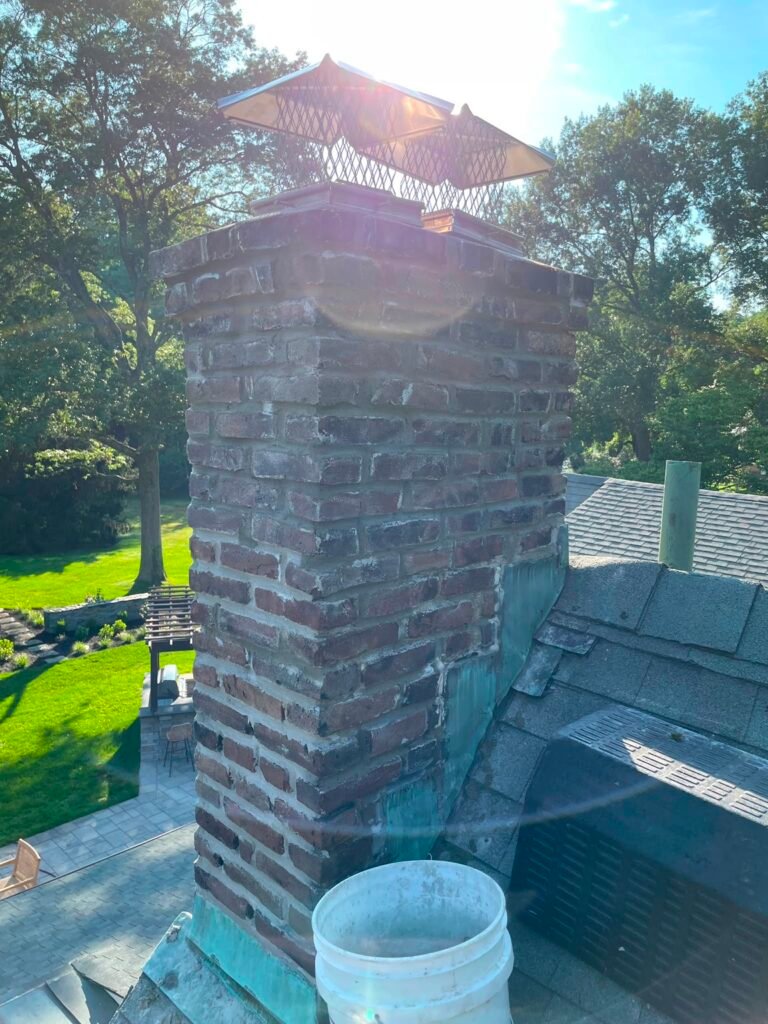 Chimney with a newly coated white crown and cap, photographed at dusk