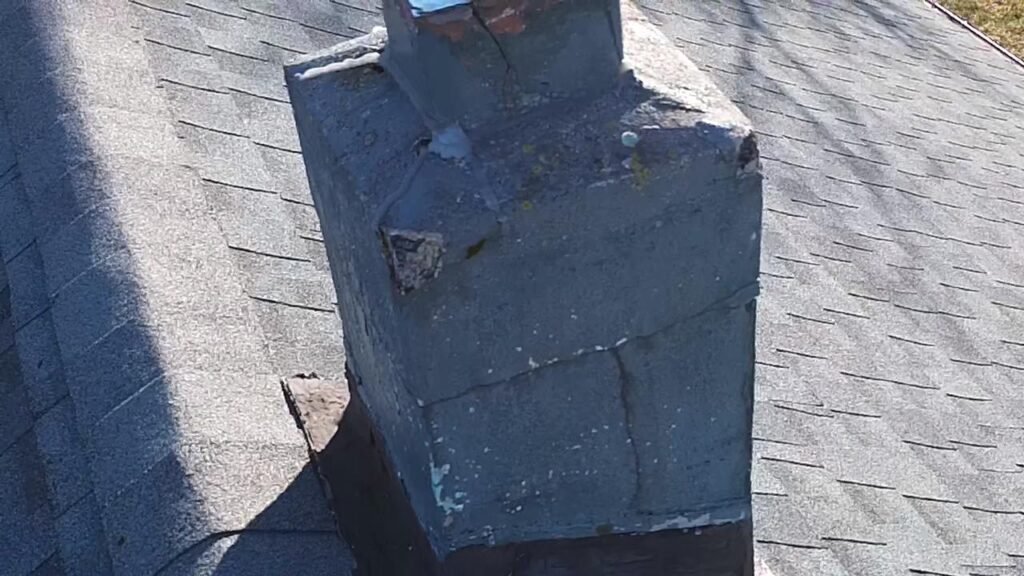 Weathered gray-blue stucco chimney with visible cracking
