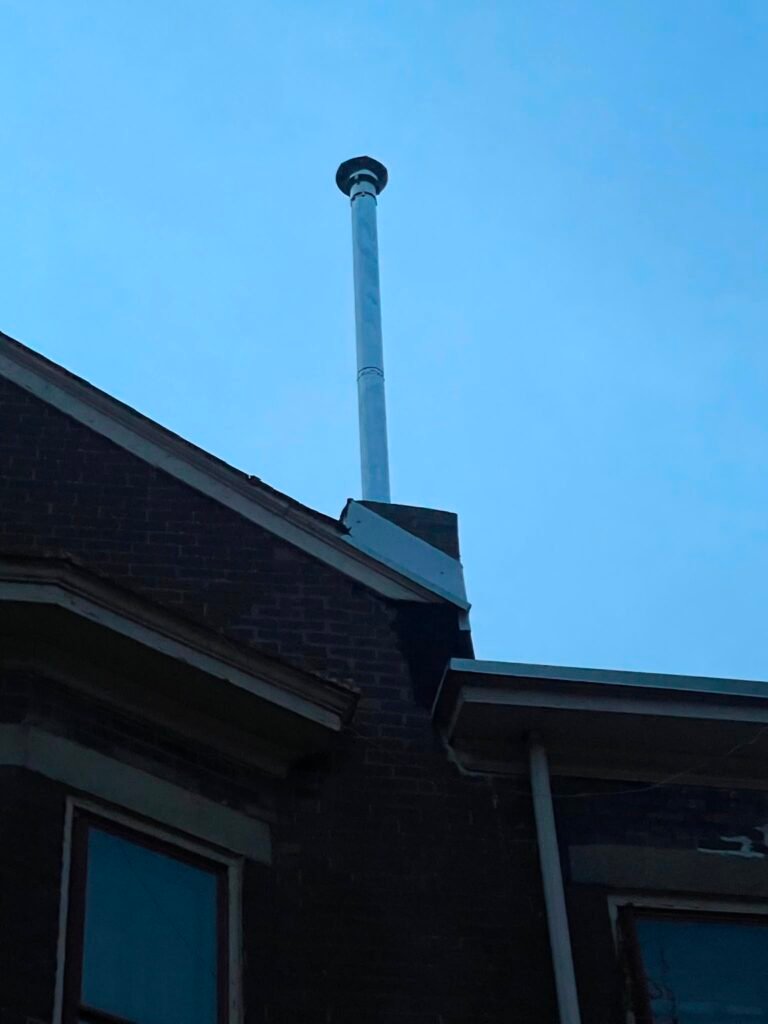 Shortened brick chimney base with a new metal flue and cap installed