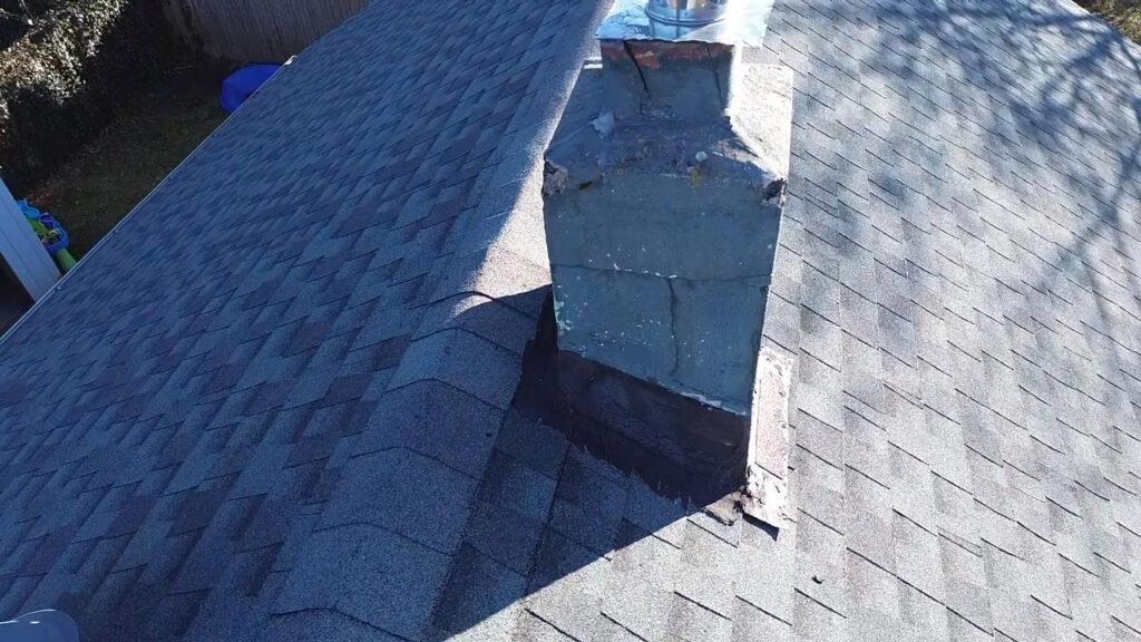 Aged chimney with cracked stucco and worn masonry top