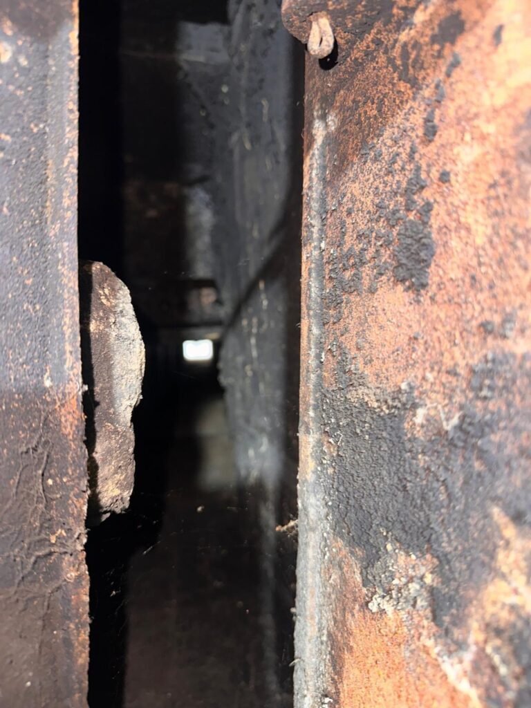 Close-up of rusted, corroded metal smoke-chamber components