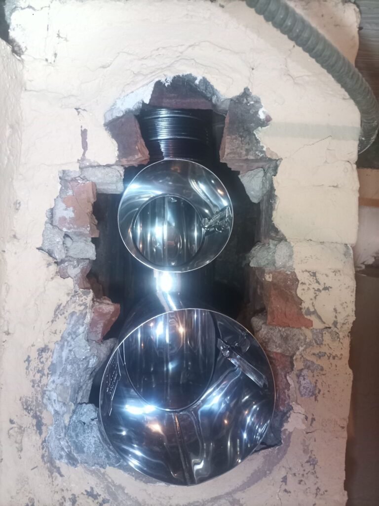 Interior view of the liner connection near a water heater and utility piping