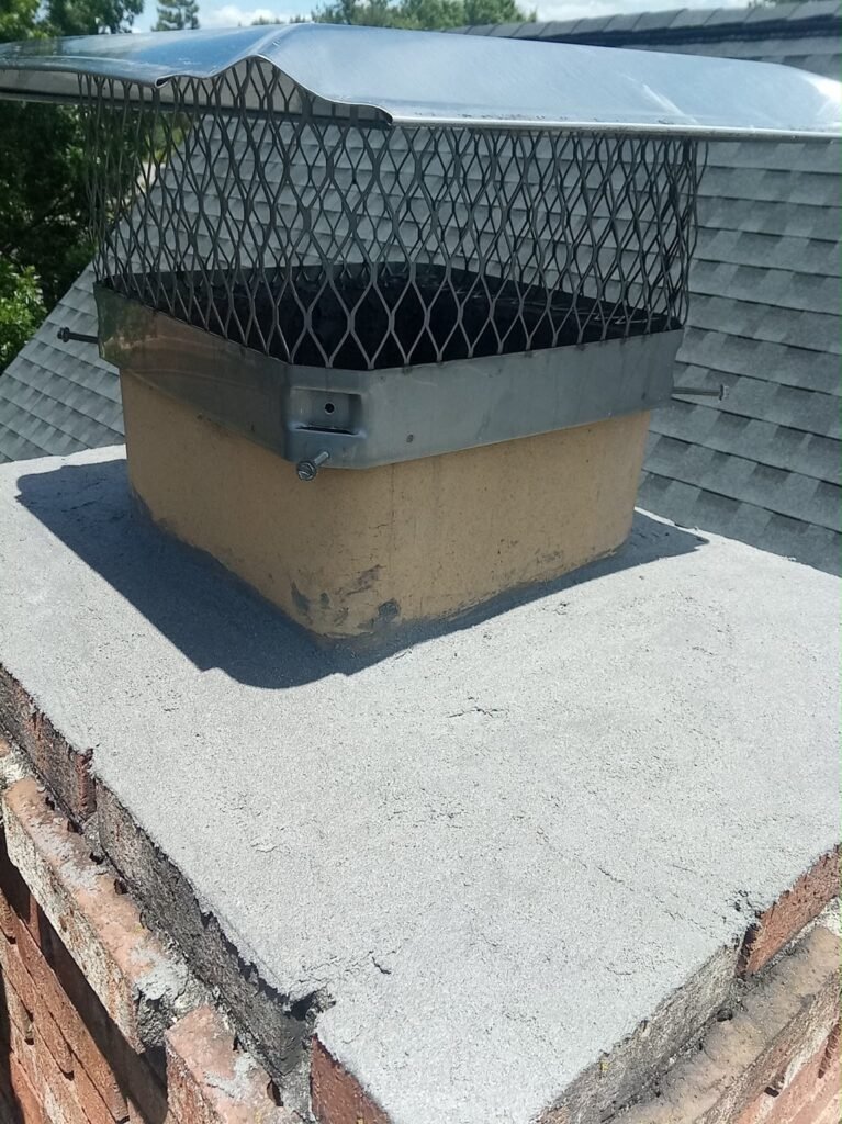Chimney top with a repaired crown and a new cap with mesh screen