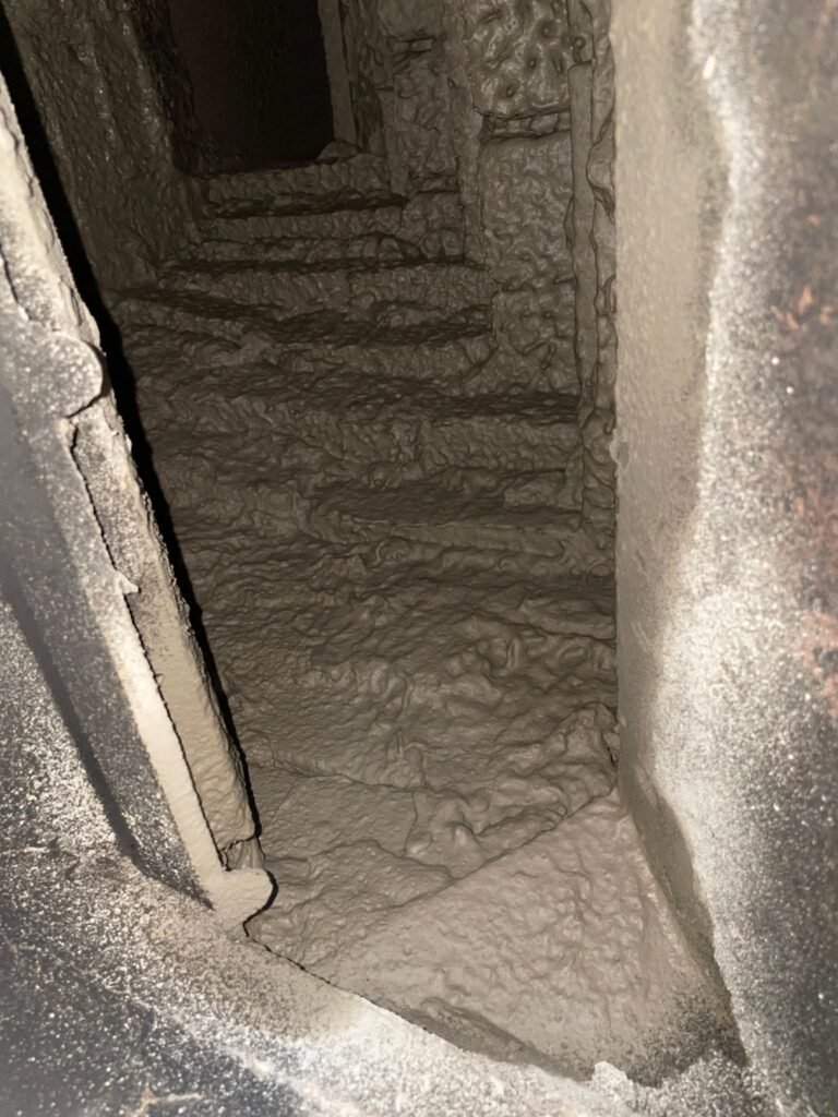 Smooth, newly coated smoke chamber interior showing the finished high-heat cement surface