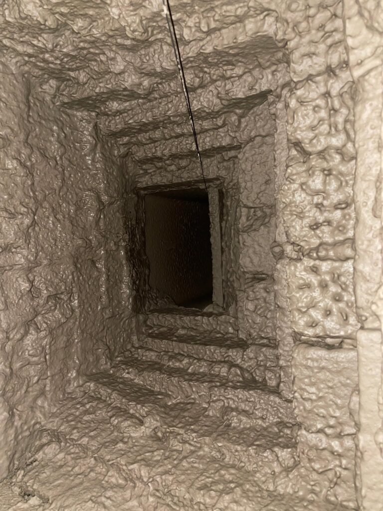 Smooth, light-gray coated smoke chamber interior with a stepped smoke shelf