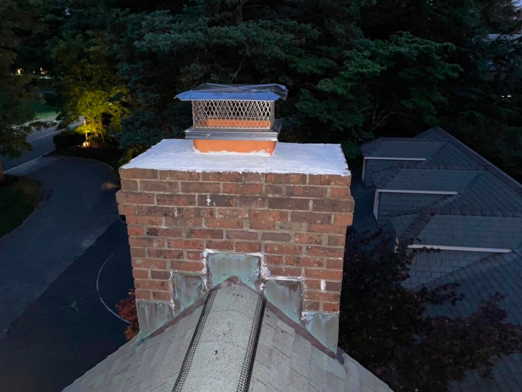 Chimney crown and existing cap viewed from the roofline